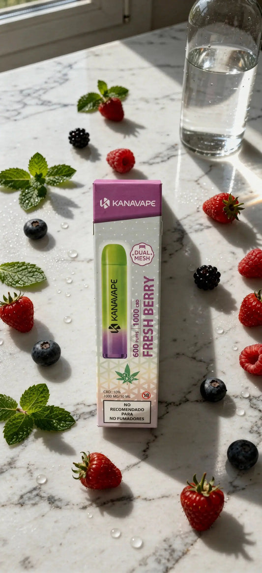 Boîte Kanavape Fresh Berry avec liquide CBD, flacon vert en évidence, fruits frais (fraises, framboises, myrtilles) et feuilles de menthe sur surface marbrée.